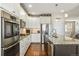 Modern kitchen with granite countertops, stainless steel appliances, and access to living area at 31353 E 163Rd Ave, Hudson, CO 80642