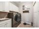 Laundry room with stainless steel washer and dryer, white cabinets, sink, and LVP flooring at 31353 E 163Rd Ave, Hudson, CO 80642