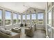 Relaxing sunroom with vaulted ceiling, large windows, and comfortable seating at 31353 E 163Rd Ave, Hudson, CO 80642