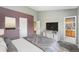 Serene bedroom features a purple accent wall, a door to the bathroom, and stylish furnishings for a modern look at 8755 W Cornell Ave # 14-5, Lakewood, CO 80227