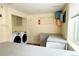 Bright laundry area boasts a modern washer and dryer, ample counter space, and unique shelving at 9687 Timbervale Ct, Highlands Ranch, CO 80129