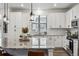 Modern kitchen showcasing white cabinets, granite countertops, stainless steel appliances, and contemporary pendant lighting at 8403 Rush Creek Ave, Littleton, CO 80125