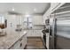 Well-equipped kitchen featuring white cabinetry, granite countertops, stainless steel appliances, and hardwood floors at 8403 Rush Creek Ave, Littleton, CO 80125