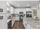 Spacious kitchen boasting white cabinets, stainless steel appliances, granite countertops, and hardwood floors at 8403 Rush Creek Ave, Littleton, CO 80125