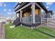 Charming covered porch features stone accents, stylish railings, and fresh lawn at 8403 Rush Creek Ave, Littleton, CO 80125