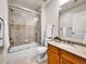 Bright bathroom featuring a shower-over-tub with sliding glass door and light wood vanity at 2200 S University Blvd # 105, Denver, CO 80210