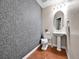 Stylish powder room with unique wallpaper, pedestal sink, and wood floors at 2200 S University Blvd # 105, Denver, CO 80210
