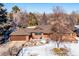 Ranch-style home with a large yard, driveway, and snow on the ground at 11539 W 27Th Ave, Lakewood, CO 80215