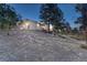 Exterior showcasing the home's setting among mature trees and landscaping, offering a sense of privacy and natural beauty at 345 Scrub Oak Way, Monument, CO 80132