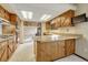 Functional kitchen with wood cabinets and eat-in breakfast bar open to the living room at 345 Scrub Oak Way, Monument, CO 80132