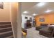 Finished basement space with brown carpet, staircase, and an orange accent wall at 9400 E Iliff Ave # 411, Denver, CO 80231