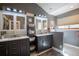 Bathroom featuring dual vanities, modern fixtures, and a window providing natural light at 9400 E Iliff Ave # 411, Denver, CO 80231