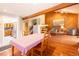 Dining room with wood floors, exposed beams, and a cozy sitting area with a fireplace at 9400 E Iliff Ave # 411, Denver, CO 80231