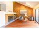 Cozy living room featuring a brick fireplace, wood floors, and ample natural light at 9400 E Iliff Ave # 411, Denver, CO 80231