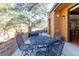 Charming outdoor patio with a metal table set and mature landscaping providing shade and privacy at 9400 E Iliff Ave # 411, Denver, CO 80231