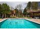 Community pool with two ducks swimming in the clean water, surrounded by mature trees and landscaped grounds at 9400 E Iliff Ave # 411, Denver, CO 80231