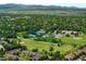Expansive aerial view of a residential community featuring green spaces, tennis courts, and mountain views at 9502 W Hialeah Pl, Littleton, CO 80123