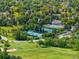 Aerial view showcasing community tennis courts and pool surrounded by lush greenery at 9502 W Hialeah Pl, Littleton, CO 80123