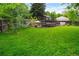 Spacious backyard with lush green grass, a trampoline, mature trees, and a privacy fence at 9502 W Hialeah Pl, Littleton, CO 80123