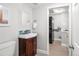 Bright bathroom featuring a mosaic tiled backsplash, stylish mirror and a stacked washer and dryer behind the door at 9502 W Hialeah Pl, Littleton, CO 80123