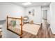 Bright hallway with hardwood floors, natural lighting and a cozy reading nook with chair at 9502 W Hialeah Pl, Littleton, CO 80123