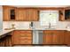 Bright kitchen featuring wood cabinetry, white countertops and modern stainless steel appliances at 9502 W Hialeah Pl, Littleton, CO 80123
