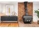 Close up view of a brick fireplace with wood-burning stove and hardwood floors at 9502 W Hialeah Pl, Littleton, CO 80123