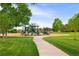 Well-maintained community playground surrounded by lush green grass and mature trees at 9502 W Hialeah Pl, Littleton, CO 80123