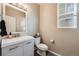 Bathroom with modern vanity, toilet, and window with blinds, offering a clean design at 10294 E Telluride Ct, Commerce City, CO 80022