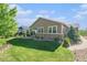 Backyard featuring lush lawn, stone patio, mature trees, and attractive landscaping at 24028 E Caleb Pl, Aurora, CO 80016