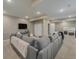 Spacious finished basement with large gray sectional sofa, tv, and neutral carpet at 24028 E Caleb Pl, Aurora, CO 80016