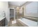 Modern bathroom with a soaking tub, glass-enclosed shower, and stylish vanity at 24028 E Caleb Pl, Aurora, CO 80016