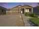 Inviting brown home with a 2-car garage, stone accents, and a welcoming front porch at dusk at 24028 E Caleb Pl, Aurora, CO 80016