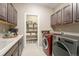 Functional laundry room with modern washer and dryer, storage cabinets, and a utility sink at 24028 E Caleb Pl, Aurora, CO 80016