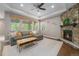 Cozy living room with stone fireplace, a neutral sectional sofa, and natural light at 24028 E Caleb Pl, Aurora, CO 80016