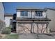 Townhouse exterior featuring two single-car garages, stone accents, and inviting entryway, surrounded by landscaping at 8354 S Everett Way # C, Littleton, CO 80128