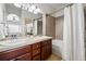 Well-lit bathroom featuring double sinks, a bathtub with tile surround, and modern fixtures at 13020 Grant W Cir # A, Thornton, CO 80241