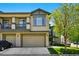 Exterior view of the two-story home with a two-car garage, porch and a well-manicured lawn at 13020 Grant W Cir # A, Thornton, CO 80241