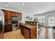 Open-concept kitchen with modern appliances, granite countertops, and adjacent dining area at 13020 Grant W Cir # A, Thornton, CO 80241