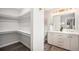 Spacious bathroom with a double vanity, modern lighting, and access to a walk-in closet at 530 Everett St, Lakewood, CO 80226
