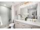 Bright bathroom with white cabinets, dual sinks, gold hardware, and a walk-in shower with neutral tile at 530 Everett St, Lakewood, CO 80226
