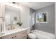 Bright bathroom with gray tiled shower, white vanity, and modern fixtures at 530 Everett St, Lakewood, CO 80226
