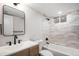 This bathroom offers a modern vanity, tub and shower combination, and a neutral color palette at 530 Everett St, Lakewood, CO 80226