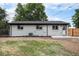 A charming home with white brick, black trim, backyard patio and privacy fence at 530 Everett St, Lakewood, CO 80226