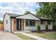 Well-maintained home showcasing light grey brick and wood accents, complemented by a manicured lawn at 530 Everett St, Lakewood, CO 80226