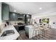 Well-lit kitchen boasts stainless steel appliances, green cabinetry, and an island with bar seating at 530 Everett St, Lakewood, CO 80226