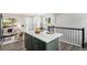 Stylish kitchen island with white countertop, wooden stools, and modern green cabinets at 530 Everett St, Lakewood, CO 80226