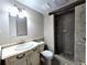 Bright bathroom with a white vanity, a toilet, and a walk-in shower with gray tiling and mosaic tile accents at 3480 S Eagle St # 101, Aurora, CO 80014