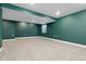 Finished basement area with green walls, carpet, and natural light from an egress window at 2640 Overlook Dr, Broomfield, CO 80020