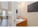 Powder bath with wooden vanity, ample mirror, and decorative wall art at 2640 Overlook Dr, Broomfield, CO 80020
